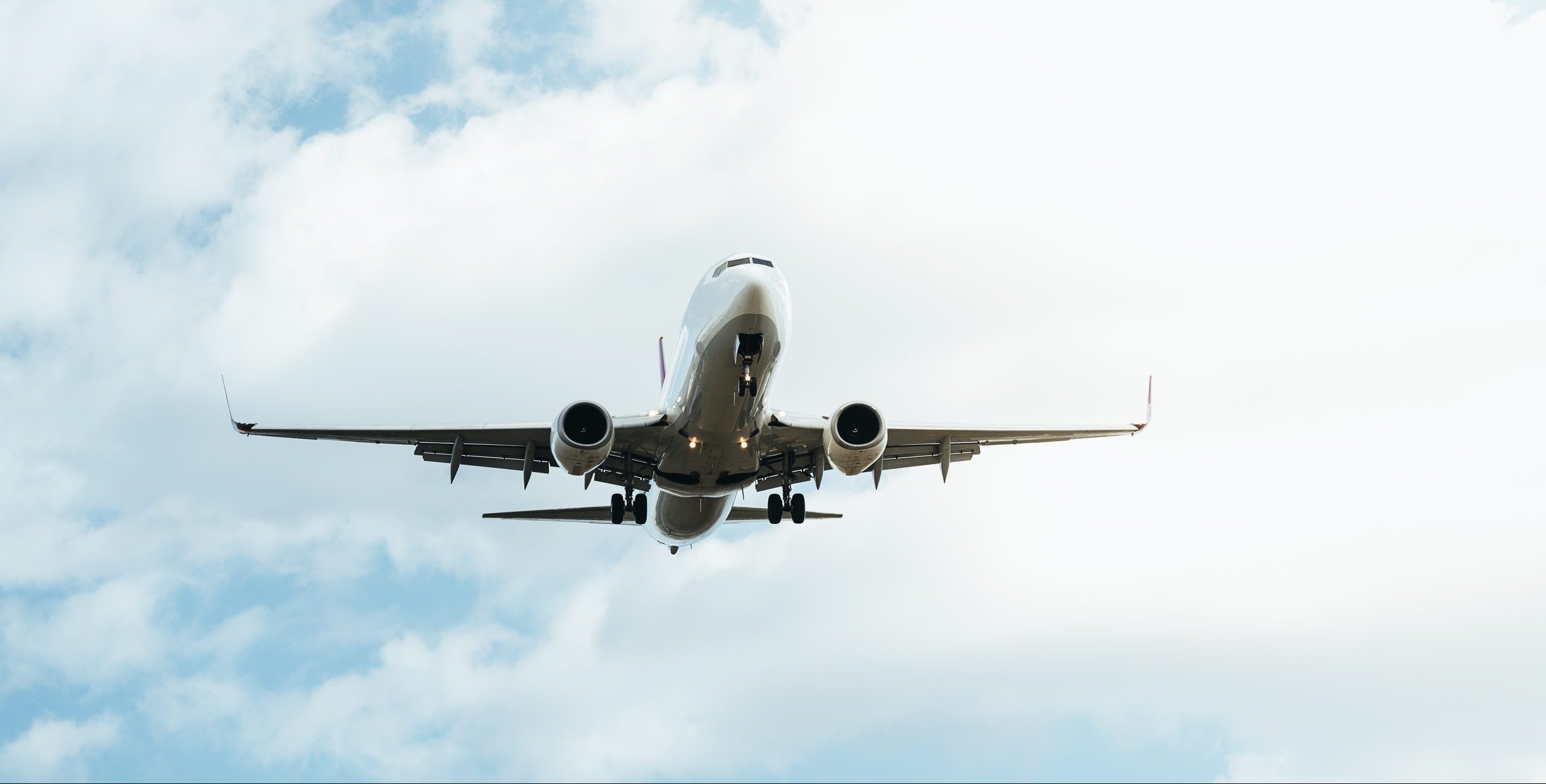 white commercial aircraft landing in a cloudy sky. Aviation disaster